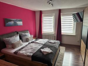 um quarto com uma cama grande e paredes cor-de-rosa em Ferienwohnung, Apartment, Monteurwohnung mit Klimaanlage Wettin - Löbejün 