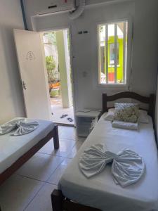 two beds in a room with a door open at Pousada Bamboo da Barra in Salvador