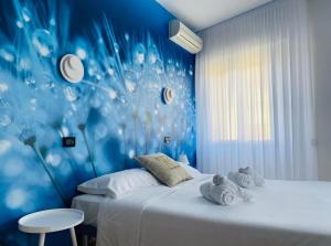 - une chambre avec 2 lits et un mur bleu dans l'établissement Hotel Hc Resort Lignano, à Lignano Sabbiadoro