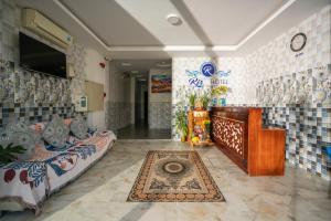 a room with two beds and a tv on the wall at Ris Hotel Đà Nẵng in Da Nang