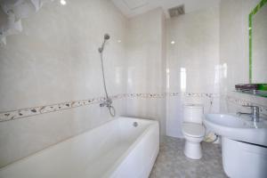 a bathroom with a tub and a toilet and a sink at Ris Hotel Đà Nẵng in Da Nang +16 photos