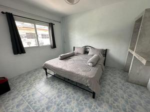 una camera da letto con letto, cuscini e finestra di Escape Divers Hostel a Ko Tao