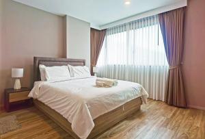 a bedroom with a large bed with a large window at Blossom Sathorn Hospitality （曼谷高端酒店公寓） in Bangkok