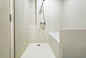 a white bathroom with a shower with a toilet at Blossom Sathorn Hospitality （曼谷高端酒店公寓） in Bangkok