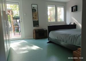 une chambre avec un lit et une porte coulissante en verre dans l'établissement La cahute, appartement T2 avec jardin ou appartement familial T6, à Montauban 27 autres photos