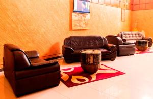 a living room with leather chairs and a table at Kalya Courts Hotel Fort Portal in Fort Portal