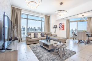 ein Wohnzimmer mit einem Sofa und einem TV in der Unterkunft Icon Casa Living - Downtown Burj Views Towers in Dubai