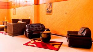 uma sala de estar com duas cadeiras e um tapete em Kalya Courts Hotel Fort Portal em Fort Portal