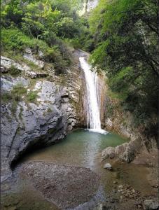 einem Wasserfall in einem Canyon mit einem Wasserpool in der Unterkunft Albergo Diffuso Borgo Piovere in Tignale in Tignale