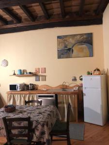 a kitchen with a table and a white refrigerator at LA CASA DEL CASTELLANO in Cinzano