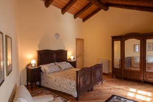 a bedroom with a bed and a large mirror at LA CASA DEL CASTELLANO in Cinzano