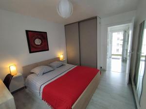 1 dormitorio con 1 cama grande con manta roja en APPARTEMENT T2 RIVE DROITE en Brest