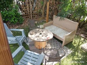 d'une terrasse avec des chaises, une table et un canapé. dans l'établissement La cahute, appartement T2 avec jardin ou appartement familial T6, à Montauban