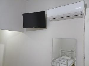 a flat screen tv hanging on a white wall at palm-tree in Arkoudi