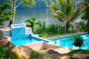 una piscina con vistas a un cuerpo de agua en Kakulanda Resort, en Kurunegala