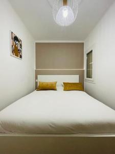 uma grande cama branca num quarto com um lustre em Chez Antho T4 - appart T4 moderne en plein cœur du Panier em Marselha