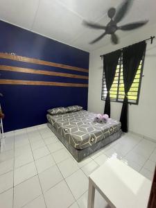 een slaapkamer met een bed en een plafondventilator bij ARYAN HOMESTAY Temerloh in Temerloh