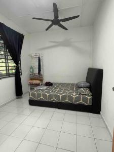 1 dormitorio con 1 cama y ventilador de techo en ARYAN HOMESTAY Temerloh en Temerloh