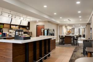 a large kitchen with a bar and a dining room at Courtyard Tupelo in Tupelo
