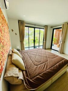 um quarto com uma cama grande e uma janela grande em Bann Chidtha family suite full kitchen near Suvarnabhumi Airport em Banguecoque
