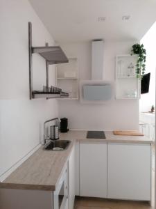 una cocina blanca con armarios blancos y fregadero en BED and BIKE - BERGAMO Home Sweet Home, en Bérgamo