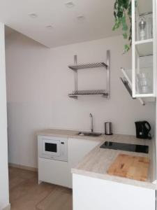 cocina blanca con fregadero y microondas en BED and BIKE - BERGAMO Home Sweet Home, en Bérgamo