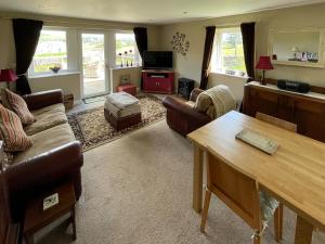 a living room with a couch and a table at Two Hoots in Wigglesworth