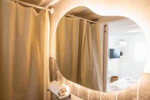 uma casa de banho com uma cortina de chuveiro e um espelho. em Mooi Boni's em Míconos