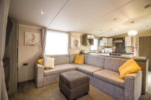 a living room with a couch and a kitchen at Modern 6 Berth Caravan With Decking At Cherry Tree Park In Norfolk Ref 70324c in Great Yarmouth