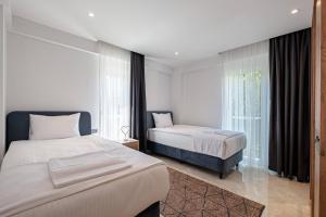 a bedroom with two beds and a window at Belek Deluxe Suit in Belek