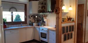 a kitchen with white cabinets and a window at La maison bois in Chaon +18 photos