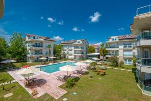 an image of an apartment complex with a swimming pool and lawn at Belek Deluxe Suit in Belek