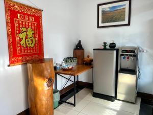 a kitchen with a table and a refrigerator at Golden flower Homestay in Yuli