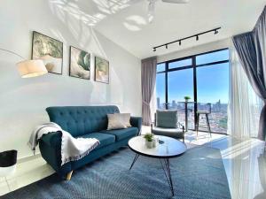 a living room with a blue couch and a table at Beacon Executive Suites #Elegant #SkyPool #Georgetown #4pax #2BR 2bath #1Queen 2Single #Quality well maintained #Private superhost in George Town +37 photos