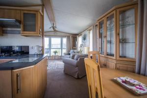 a kitchen and living room with a table in a caravan at Stunning 6 Berth Caravan At Manor Park In Hunstanton Norfolk Ref 23194k in Hunstanton