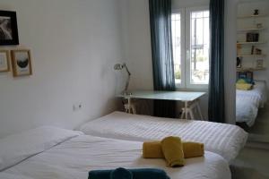 um quarto com 2 camas, uma secretária e uma janela em El patio de Nervión. em Sevilha