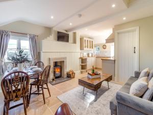 a living room with a dining room table and a fireplace at The Lodge in Wonastow
