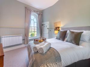 a bedroom with a large white bed with a window at The Lodge in Wonastow
