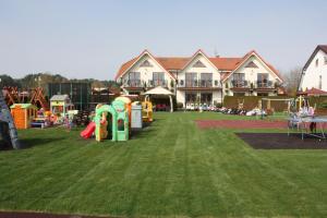 a large yard with a playground in front of a house at Willa Klif in Rowy