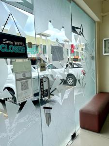 a glass wall with a car parked in a parking lot at Hotel Premier Inn (Prima Square) in Sandakan