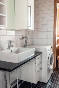 ein weißes Badezimmer mit einem Waschbecken und einer Waschmaschine in der Unterkunft 2ndhomes Stylish 1BR home with Balcony and Sauna in Kamppi Center in Helsinki