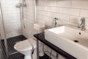 a white bathroom with a sink and a toilet at 2ndhomes Stylish 1BR home with Balcony and Sauna in Kamppi Center in Helsinki +17 photos