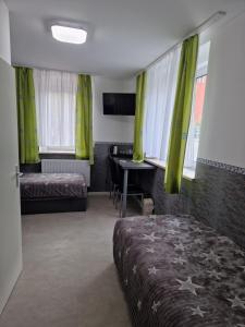 een slaapkamer met groene gordijnen, een bed en een bureau bij Pension Valentina in Mühlau