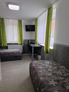 Schlafzimmer mit einem Bett, einem Schreibtisch und Fenstern in der Unterkunft Pension Valentina in Mühlau