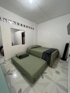 a white room with two beds and a mirror at Apartamento a 5 minutos del parque principal in Jardin