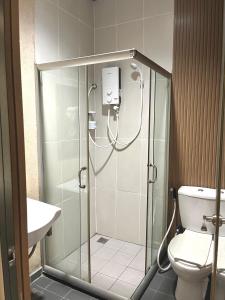 a bathroom with a shower with a toilet and a sink at Hotel Premier Inn (Prima Square) in Sandakan