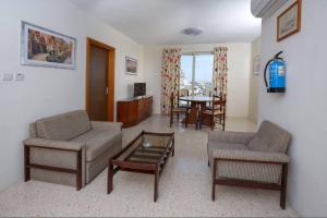 a living room with a couch and chairs and a table at Seaview Penthouse Balluta Bay VC in St Julian's