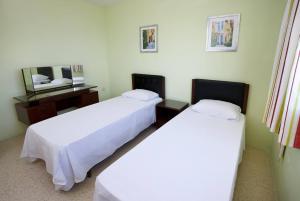 a room with two beds and a desk with a mirror at Seaview Penthouse Balluta Bay VC in St Julian's