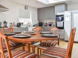 a kitchen with a wooden table and chairs in a kitchen at Sunnyside in West Mersea