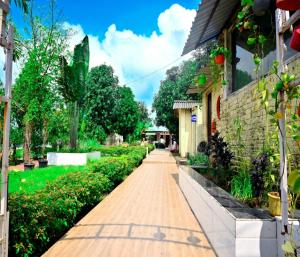 a walkway in a garden next to a building at KK Tree Retreat Igatpuri in Igatpuri